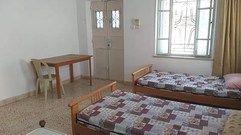 The big room with single wooden beds and shelves