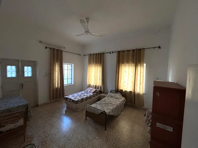 A bedroom with old double doors with iron-patterned glass