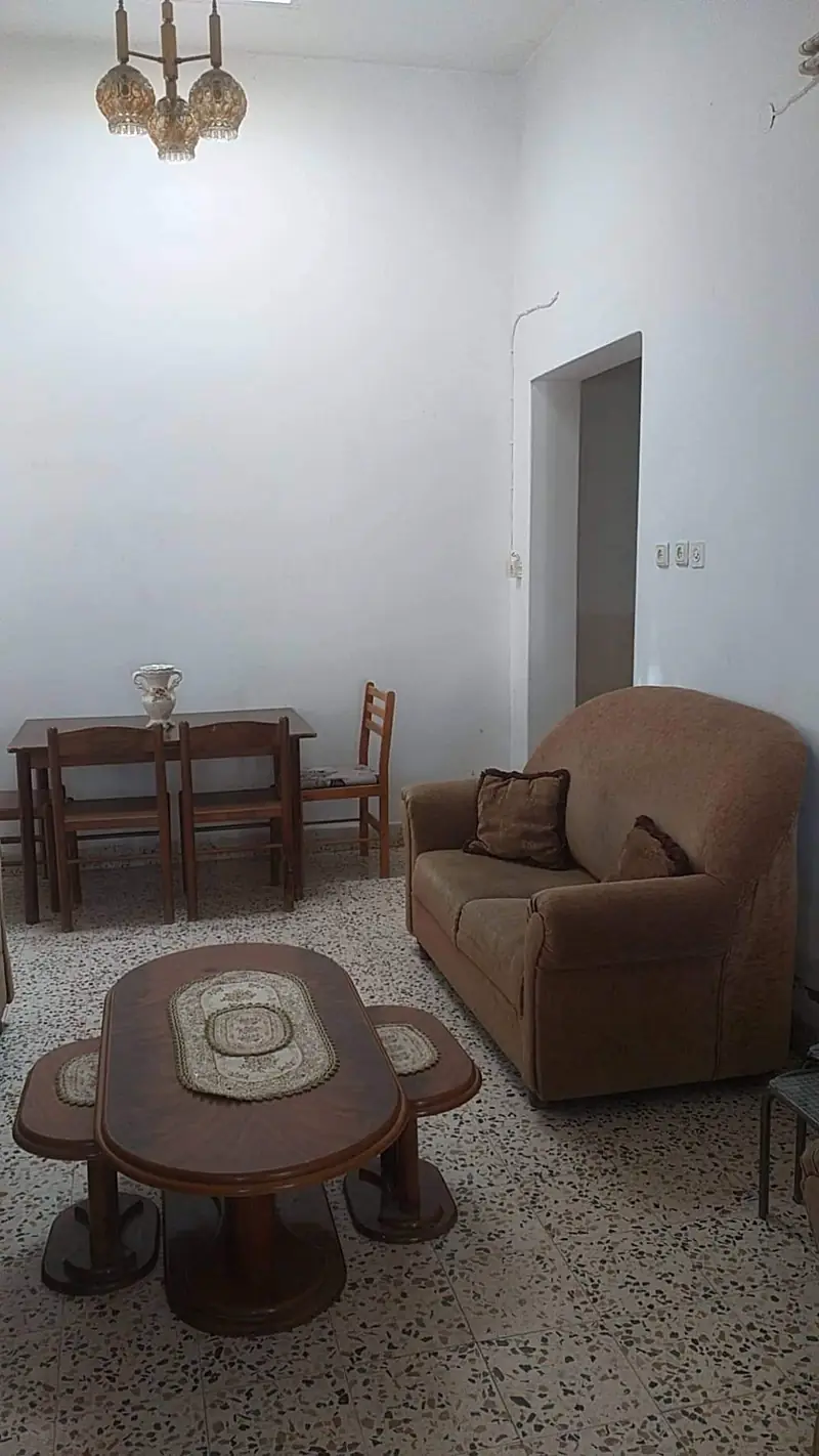 The living room with sofas, a carved coffee table and an amber chandelier