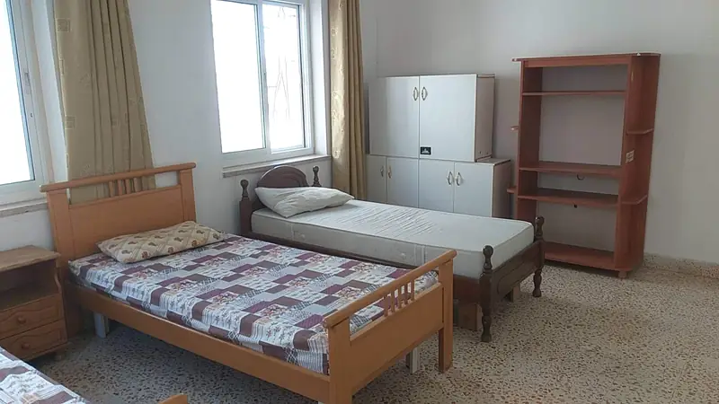 A bedroom with two single beds under the window